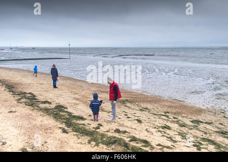 Una famiglia di brave il freddo sulla campana Wharf beach a Leigh on Sea, Essex. Foto Stock