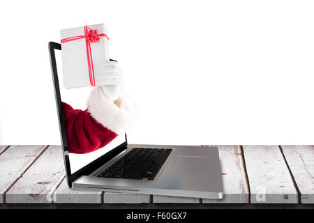Immagine composita di santa mostra un presente tenendo premuto segno Foto Stock