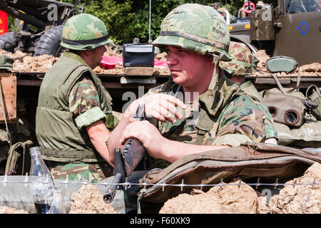 Guerra del Vietnam "Rolling Thunder" rievocazione gruppo. Marine in stand by, avviso in piedi in trincea, mano e braccio poggiando sulla M16. Close up. Foto Stock