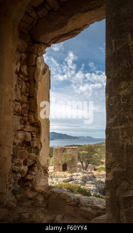 Vista dell'edificio abbandonato e la costa della Corsica ripresa attraverso una finestra di pietra telaio presso il castello in rovina di Pierre-Napoleon B Foto Stock