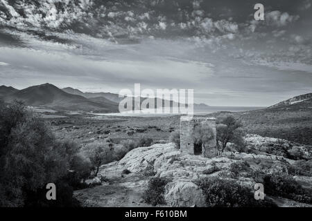 Bianco & Nero vista dell edificio abbandonato costruita su sperone di roccia e la costa della Corsica ripresa da un castello in rovina Foto Stock