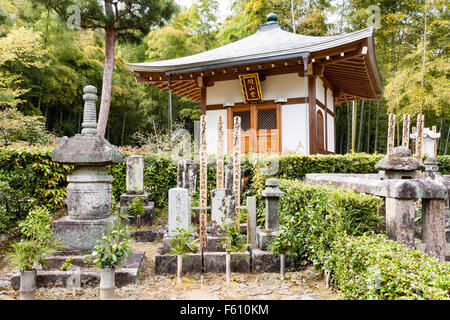 Giappone, Kyoto Arashiyama, Jojakko-ji tempio. Piccolo mausoleo, square pavilion con gravi e marcatori di sotoba di legno davanti e dietro della foresta. Foto Stock