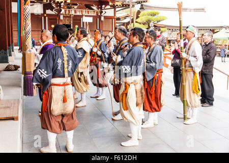 Giappone, Nishinomiya, Mondo Yakuji tempio. Un gruppo di sacerdoti che indossa yamabushi, (monaco guerriero), costumi, pregando con testa sacerdote a temple hall. Foto Stock