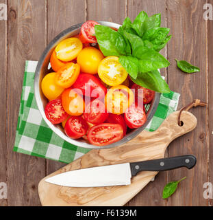 Colorate freschi pomodori e basilico in scolapasta. Vista superiore Foto Stock