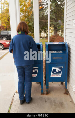 Una donna spedire una lettera in una cassetta postale statunitense, Vermont USA Foto Stock