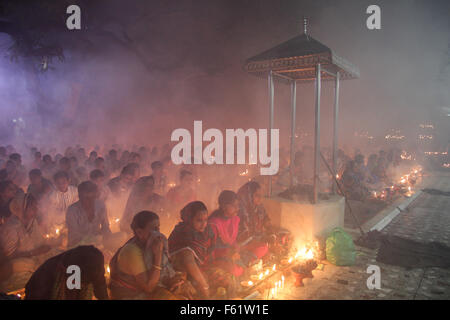 Naryanganj, Bangladesh. Decimo Nov, 2015. Devoti indù osservare il 3° giorno di Rakher Upobash a "Baba Loknath Ashrom', Barodi. Ogni anno migliaia di devoti indù si riuniscono di fronte di Shri Shri Lokenath Brahmachari Ashram tempio per il Kartik Brati o Rakher Upobash festival religioso in Barodi, vicino a Dacca in Bangladesh. Fedeli di sedersi di fronte luce delle candele ( chiamato localmente come Prodip ) e assorbire nella preghiera. Credito: Belal Hossain Rana/Pacific Press/Alamy Live News Foto Stock