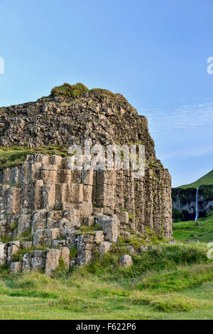 Basalto colonnare affioramento (e cascata di sfondo), Dverghamrar Nana (scogliere), vicino a Foss, Islanda Foto Stock