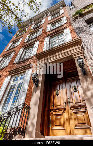 Quattro piani di townhouse a Chelsea, Manhattan. Tipico di New York City townhouse architettura con porta in legno e pareti in mattoni. Foto Stock