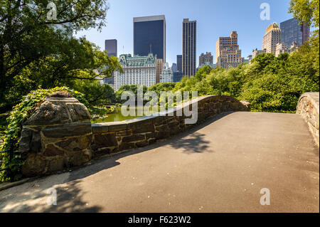 Gapstow Bridge e lo stagno su una mattina di primavera con vista dei grattacieli di Manhattan, al Central Park di New York City Foto Stock
