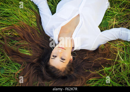 Giovane e bella donna di relax all'aperto in erba verde Foto Stock