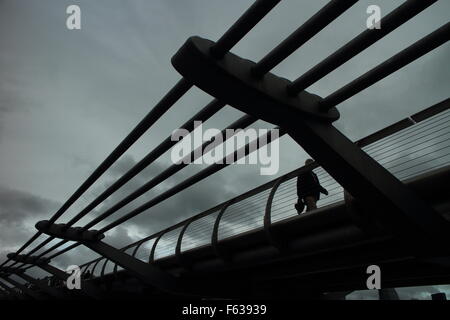 La gente che camminava sul Millennium Bridge di Londra in un giorno di pioggia Foto Stock