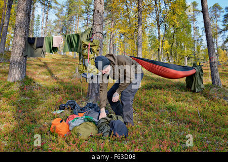 Trekker tenetevi pronti per una notte in un'amaca. Urho Kekkonen National Park, Lapponia, Finlandia. Foto Stock