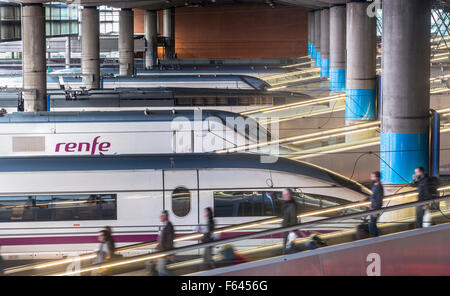 Ad alta velocità e i treni pendolari a loro piattaforme nella stazione ferroviaria di Atocha, Madrid, Spagna Foto Stock