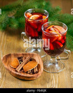 Due bicchieri di vino brulé e spezie su sfondo di legno Foto Stock