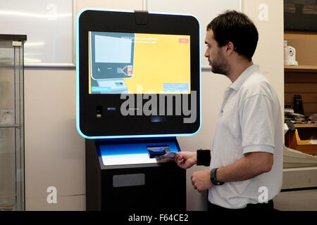 Giovane maschio utilizzando una valuta digitale bitcoin atm England Regno Unito Foto Stock