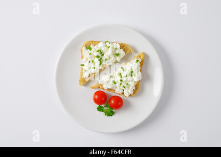 Due fette di pane tostato con il formaggio sulla piastra bianca Foto Stock