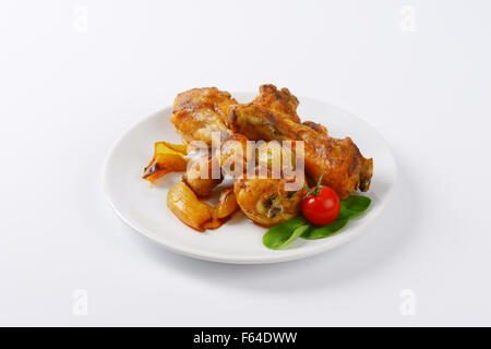 Appena tostato le cosce di pollo e verdure sulla piastra bianca Foto Stock