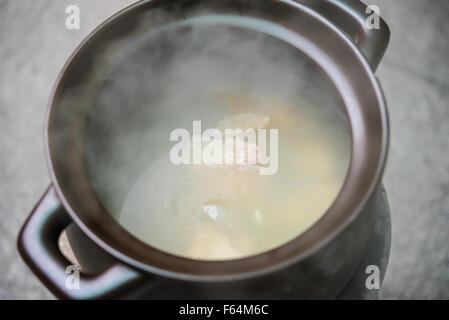 Cottura della zuppa con bricchette di carbone forno Foto Stock