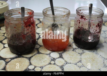 Tre tipi di fresco inceppamenti appetitosi dal dolce di mele mature, Lamponi Mirtilli rossi selvatici in vetro Foto Stock