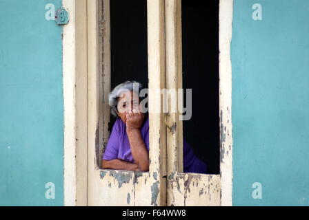 Donna anziana guardando fuori della finestra, Vinales, Cuba Foto Stock