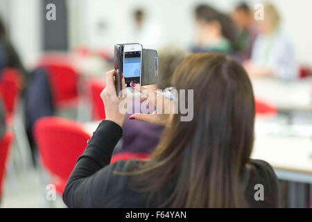 Una donna usa uno smartphone per scattare una foto Foto Stock