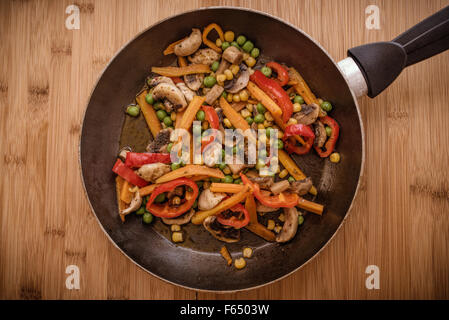 Frypan e verdure su sfondo di legno Foto Stock