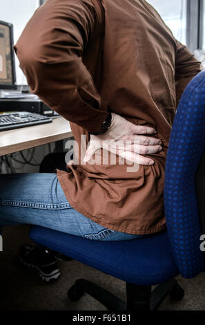 Un dipendente si siede alla sua scrivania in ufficio e mantiene il suo male torna a Dresda (Sassonia), Germania, 04 febbraio 2015. Foto: Thomas Eisenhuth/dpa Foto Stock