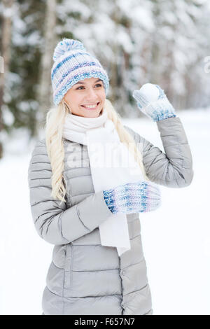 Sorridente giovane donna nella foresta di inverno Foto Stock