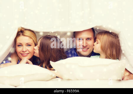 Felice famiglia con due bambini sotto coperta a casa Foto Stock