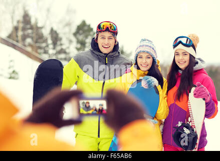 Happy amici con racchette da neve e lo smartphone Foto Stock