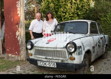 Sacerdote Maltese Imre Kozma e Antje Liebsch con un originale Trabant e un pezzo del muro di Berlino, Budapest, Ungheria Foto Stock