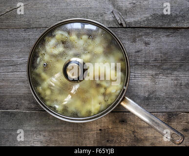 Nov. 3, 2015 - Patate fritte nello strutto nella padella in acciaio inox coperchio in vetro chiuso su weawering tavolo in legno © Igor Goiovniov/ZUMA filo/Alamy Live News Foto Stock