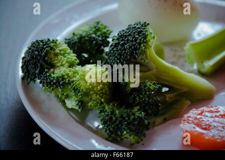 Broccoli freschi placcato su un verde bluastro sfondo con altri ingredienti salutari. basso-chiave illuminazione, profondità di campo Foto Stock