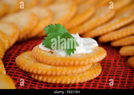 Crackers impilato con diffusione e guarnire su una tela rosso sfondo, cracker sparsi Foto Stock