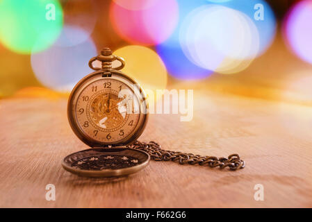 Orologio retrò con bokeh su sfondo di legno Foto Stock