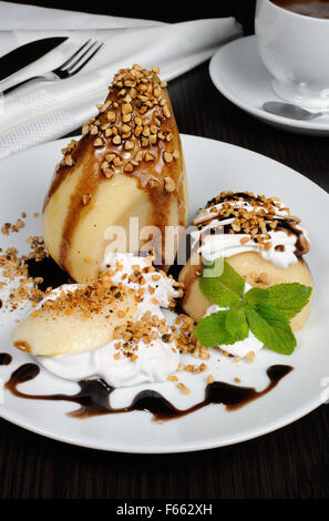 Pere con panna montata spruzzata noci, mandorle e cioccolato Foto Stock