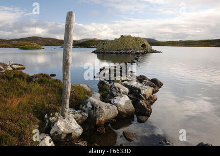 Selciato in pietra che conduce a Dun Baravat Età del Ferro galleria che ospita la connessione DUN o broch su una piccola isola nel Loch Barabhat, grande Bernera, isola di Lewis. Foto Stock