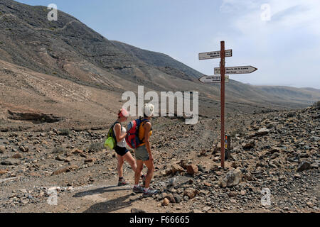 Gli escursionisti al cartello nel Barranco la Huguera, Femés, Lanzarote, Isole Canarie, Spagna Foto Stock