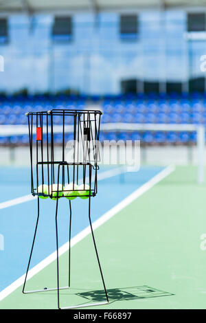 Bellissimo campo da tennis con una palla canestro e palle da tennis in esso Foto Stock