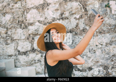 Bella ragazza tenendo un selfie e avere un buon tempo durante il periodo estivo Foto Stock