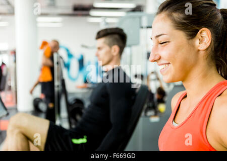 Un uomo bello e una bella donna che lavorano insieme in una palestra e incollaggio Foto Stock