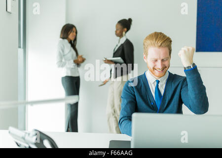 Imprenditore di successo di essere felice per il raggiungimento dei suoi obiettivi come vede la buona notizia sul laptop Foto Stock