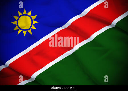 E ondulato increspato bandiera nazionale della Namibia sfondo. Foto Stock