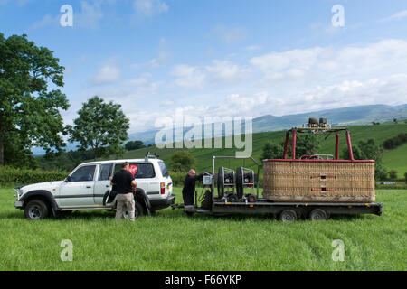 4x4 veicolo e il rimorchio di prelevare una mongolfiera dal campo dopo un volo, Cumbria, Regno Unito. Foto Stock