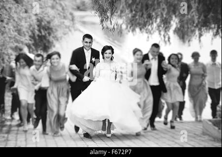 Felice sposa in esecuzione con essi amici Foto Stock