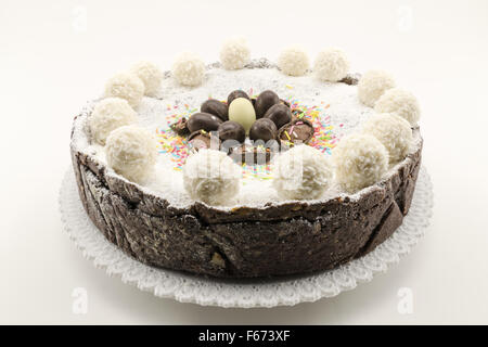 Torta di Pasqua con ripieno di ricotta e cioccolato decorate con uova di cioccolato e di zucchero a velo Foto Stock