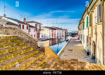 I colori intensi delle abitazioni storiche di Comacchio, città conosciuta come la piccola Venezia in Emilia Romagna, un incantevole città lagunare con ponti e canali in esecuzione attraverso di esso Foto Stock