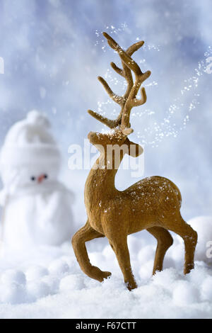 Natale renne figura in scena di neve con pupazzo di neve in background Foto Stock