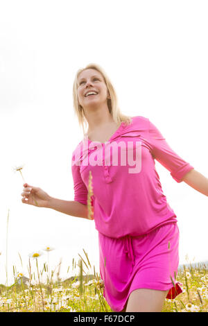 Bella donna godendo di daisy in un campo Foto Stock