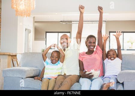 La famiglia felice guardando la televisione mangiare popcorn Foto Stock